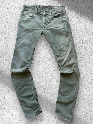 Gröna Replay Anbass Jeans - Klassiska Replay Anbass jeans i grön tvätt. Jeansen är i mycket bra skick och sparsamt använda. Anbass är slim fit!  | Storlek: W32/L34 (normal i storleken) | Skick: Bra skick! Tyvärr sitter en tråd på bakre fickan löst (se sista bilden!) | Färg: grön | Märke: Replay | Modell: Anbass  | Hör gärna av dig vid frågor så svarar jag så fort jag kan! 😁