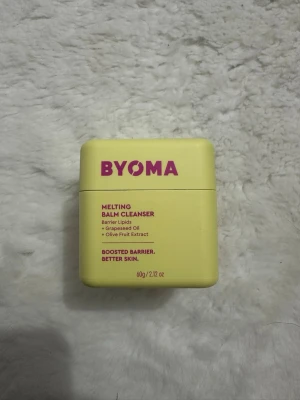 BYOMA Melting Balm Cleanser 60g - En ljusgul fyrkantig burk med BYOMA Melting Balm Cleanser, innehåller 60g. Rengöringsbalmen är berikad med barriärlipider, druvkärneolja och olivfruktextrakt. Perfekt för att boosta hudens barriär och ge en fräsch känsla. Snygg och modern förpackning.