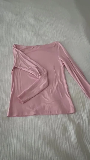 Ljusrosa långärmad topp från Lager 157 - Säljer en ljusrosa långärmad topp från Lager 157 i storlek S. Toppen har en enkel och stilren design med rund hals och är tillverkad i ett mjukt och stretchigt syntetmaterial som känns skönt mot huden. Perfekt att matcha med jeans eller kjol för en chill look.