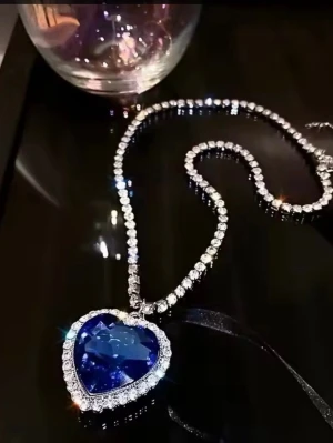 💙Nytt lyxigt Blått hjärthalsband💙 Titanic halsband med presentpås Stor berlock 💙 - Säljer ett vackert elegant halsband med ett stort hjärtformat blå safir i glasprisma. Hänget är dekorerat med glittrande stenar utav strass. Kedjan är dekorerad med gnistrande kristaller och hänget har en riktigt lyxig vibe. Perfekt för dig som vill sticka ut och älskar statement-smycken. Mått hänge: 4CM x 4CM Längd kedja: ca: 42CM. Kontakta mig gärna innan köp. * leverans ca:2-3 vardagar. Nås på mobil s ges ut vid intresse. 99kr inklusive frakt. Två frimärken 36kr.