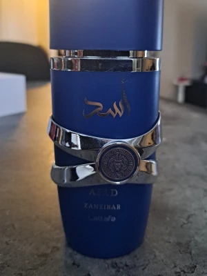 Lattafa asad Zanzibar  - Lattafa Asad Zanzibar är en populär, tropisk orientaliskt-kryddig eau de parfum från 2024 för män, känd för sin fräscha men djupa doftprofil med noter av svartpeppar, lavendel, salt, kokosvatten, iris, vanilj och rökelse, vilket skapar en känsla av äventyr och strandliv, med en lockande mix av kryddighet, sälta och söt vanilj.  Doftprofil Toppnoter: Svartpeppar, Havslavendel. Hjärtnoter: Salta kokosvatten, Iris. Basnoter: vanilj, rökelse 