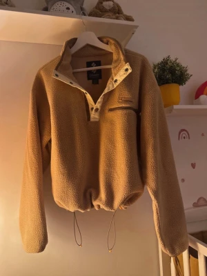 Beige fleece-tröja från Columbia - Säljer en beige fleece-tröja från Columbia med lång ärm och half zip framtill. Tröjan har en praktisk bröstficka med dragkedja och snörning i nederkant för att justera passformen. Perfekt för kyliga dagar och outdoor-häng. Oanvänd 🫶🏻♥️