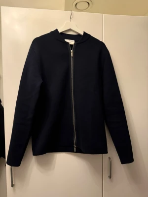 Mörkblå kofta med dragkedja från  - Snygg mörkblå kofta från selected home med rak passform och hel dragkedja framtill. Tröjan har långärmade ärmar och är tillverkad i ett stickat material som känns mjukt och bekvämt. Perfekt för lager-på-lager under hösten och vintern.