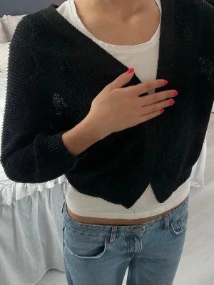 Svart stickad kofta från Cubus - Säljer en svart stickad kofta från Cubus i storlek M. Koftan har långärmade ärmar och en loose passform, perfekt att slänga över en t-shirt. Enkel design utan knappar eller dragkedja, med grovstickad struktur som ger en chill vibe.