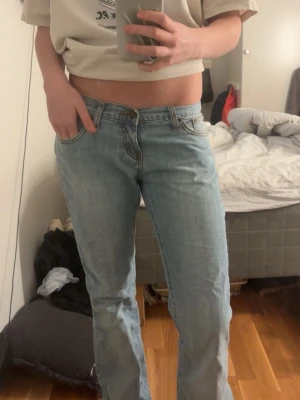Ljusblå bootcut jeans från Levi's - Säljer ett par ljusblå jeans från Levi's med klassisk femficksdesign och låg midja. Modellen har bootcut-snitt som ger en schysst siluett och är tillverkad i mjukt jeanstyg. Perfekt för dig som gillar retrovibbar och avslappnad stil.