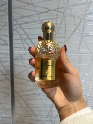 Aqua Allegoria Mandarine Basilic - Lyxig parfym från Guerlain med elegant design och guldiga detaljer. Flaskan har märkningen 'Aqua Allegoria Forte Mandarine Basilic' och är tillverkad i Paris. Perfekt för dig som vill sticka ut med en exklusiv touch.