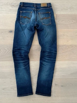 Straight fit nudie jeans - Snygga mörkblå jeans från Nudie Jeans i modellen slim/straight fit. Galen honey comb och slitningar där fram håll i en av framfickorna men det går att fixa grattis vid en av nudies affärer då de har life time repears w30 l34