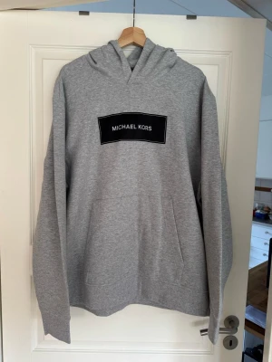 Michael Kors Hoodie helt ny - Hoodie är grå med vit svart märke på bröstet 