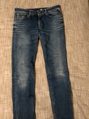 Replay skinny jeans blå, stl 31 - Säljer ett par blå skinny jeans från Replay i storlek 31. Jeansen har klassisk femficksdesign, snygga slitningar och Replay-lapp bak i midjan. Materialet är jeans med en schysst tvätt och smal passform som sitter tight hela vägen ner.