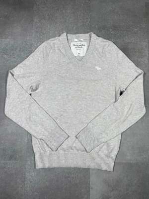 Cashmere abercrombie & fitch tröja - Säljer en Abercrombie & Fitch cashmere sweater i snygg grå färg. 🧵 Märke: Abercrombie & Fitch 👕 Storlek: M 🎨 Färg: Grå 📌 Design: Klassisk stickad tröja i cashmere 📍 Skick: Mycket bra, se bilder!  Beskrivning: • Tidlös och stilren design från Abercrombie & Fitch • Bekväm och varm – perfekt för höst och vinter • Mjukt cashmere-material som känns lyxigt mot huden • Inga fläckar, noppor eller skador (kontrollera bilder) • Lätt att matcha med jeans, chinos eller över skjorta  Har du några frågor kan 