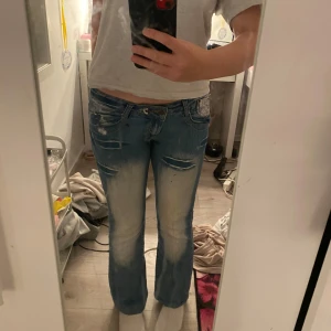 Lågmidjade jeans  - Bra skick snygga detaljer sytt dit en extra knapp vid midjan, snygga detaljer och jeansen säljs inte längre utan det är gamla 