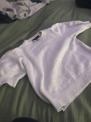 Vit stickad tröja Vero Moda XS - Säljer en vit stickad tröja från Vero Moda i storlek XS. Tröjan har korta ärmar med ribbade muddar och rund halsringning. Mjuk och skön känsla, perfekt för lager-på-lager under kyliga dagar. Enkel och stilren design som passar till många olika outfits. bra passform