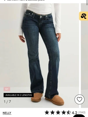 Bootcut mörkblå jeans från Nelly - Snygga bootcut jeans i mörkblå tvätt från Nelly. Modellen har låg midja, klassiska fem fickor och dragkedja med knapp. Jeansen är tillverkade i ett stretchigt bomullsmaterial som sitter bekvämt och ger en schysst siluett.