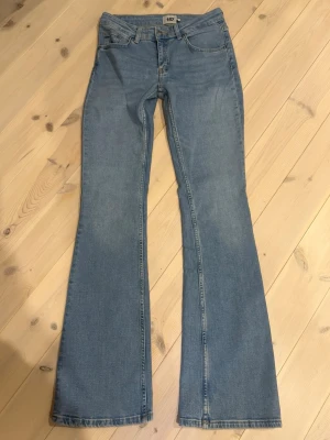 Bootcut jeans i ljusblå denim - Snygga bootcut jeans i ljusblå denim med klassisk femficksdesign och knappgylf. Jeansen har en lätt utsvängd passform nedtill. Jeansen har låg midja. 