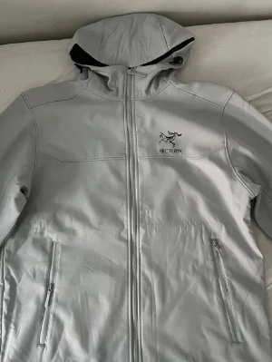 Arc'teryx vindjacka - Arc'teryx vindjacka i grå med huva och hel dragkedja framtill.  Finns i alla storlekar