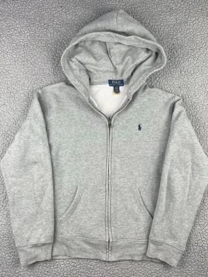 Grå hoodie från polo Ralph lauren - Säljer denna fina hoodie från polo Ralph lauren. Bra skick, möjligtvis något urtvättad. Skickar snabbt efter att du har gjort en beställning. Frågor? Skicka ett meddelande👍L 14-16= ca storlek XS