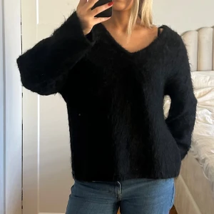 Svart fluffig stickad tröja v-ringad - Din srixksd tröja med v ringning, aldrig använd. Polyamid 33%, Mohair 32%, Ull 32%, Elastan 3%