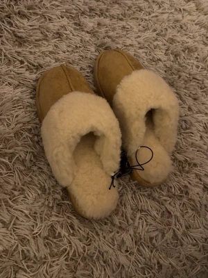 Beige tofflor 39  - Beige fluffiga tofflor ifrån Race Marine, storlek 39. Aldrig använda då jag fick dubbletter, prislapp kvar. Väldigt varma!! Grov sula. Små i storleken. Nypris 249 kr
