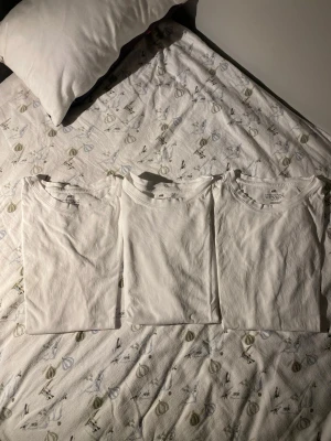 Vit basic t-shirt från H&M - Tre vita basic t-shirts från H&M i storlek 158/164. Klassisk rund hals och korta ärmar, tillverkade i mjuk bomull som är skön mot huden. Perfekt för dig som gillar enkel och clean stil. Säljes som paket!