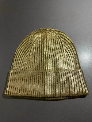 Guldig ribbad mössa från Zara - Kaxig guldig mössa från Zara med ribbad struktur. Mössan har en uppvikt kant och är tillverkad i ett metallic material som verkligen sticker ut. Perfekt accessoar för dig som vill sticka ut lite extra med självförtroende 😎Passar S/M. Mycket bra skick, som ny! Säljs på flera sidor, först till kvarn. 