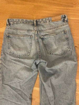 Ljusblå raka jeans  - Säljer ett par ljusblå jeans med klassisk femficksmodell och raka ben. Jeansen har normal midja och är tillverkade i slitstarkt bomullsdenim. Perfekta för en avslappnad och trendig look.