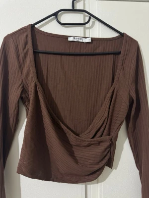 Brun topp  - En brun topp i stl S som aldrig är använd säljs för 100 kr. 