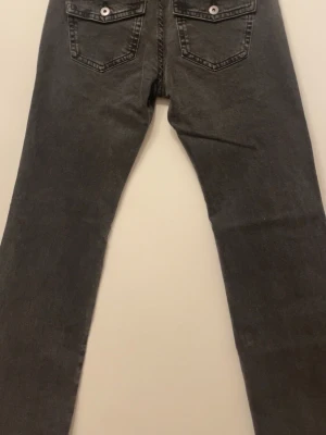 Bootcut-jeans med fickor - OANVÄND! Grå bootcut-jeans i storlek 36 – med lappen kvar. Figurnära och stretchiga med låg midja och snyggt utsvängda ben. Praktiska fickor fram och bak med knappdetalj. Perfekt passform för dig som är 160 cm eller kortare – bekväma, smickrande och lätta att matcha.🩷
