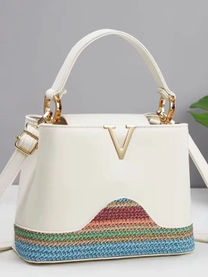 Vit handväska med färgglad botten - Snygg vit handväska med guldfärgade detaljer och ett stort V framtill. Botten har ett stickat randigt mönster i blått, grönt, rosa och beige. Väskan har både handtag och axelrem, perfekt för att bära på olika sätt. Stilren design med en färgklick som gör den unik.