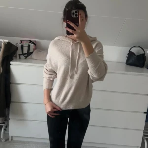 Beige stickad hoodie från Lindex - Mysig beige stickad hoodie från Lindex i storlek XS💕. Tröjan har huva med snörning och långa ärmar, perfekt för kyliga dagar. Den är har används en del gånger och har därför blivit lite nopprig🥰