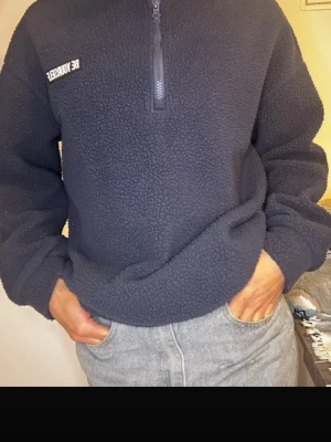 Mörkblå fleece half zip-tröja - Mysig mörkblå fleece-tröja från Be Yourself med half zip och hög krage. Tröjan har en relaxed passform och är perfekt för kyliga dagar. Broderad logga på bröstet och långa ärmar. Superenkel att styla med jeans eller mjukisbyxor.