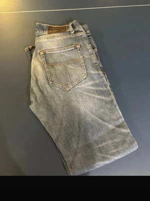 Tiger of Sweden blå jeans Pistolero 30/32 - Säljer ett par klassiska blå jeans från Tiger of Sweden i modellen Pistolero. Jeansen har fem fickor, snygga slitningar och kontrastsömmar. Passar dig som gillar en tidlös look med raka ben och normal passform. Perfekta till sneakers eller boots.