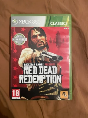 Red Dead Redemption Xbox 360 Classics - Red Dead Redemption till Xbox 360 i Classics-version. Komplett med fodral, manual och skiva. Skivan ser ut att vara i gott skick. Ett prisbelönt actionäventyr i vilda västern-miljö. Med kartan PEGI 18.
