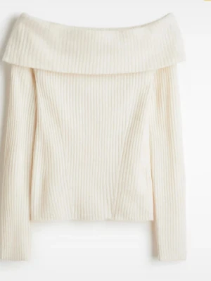 Vit ribbad offshoulder stickad tröja - Supersnygg vit/beige/creméfärgad stickad tröja med ribbad struktur och bred offshoulder-krage. Perfekt för dig som gillar en stilren look med lite extra edge. Långärmad och mjuk, passar till både jeans och kjol.