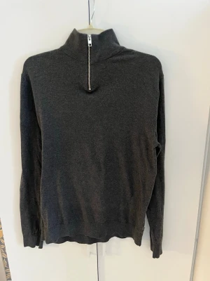 Grå stickad halv-zip - Grå halv-zip från Jack&Jones. Knappt använd. Storlek M. Skriv vid frågor eller funderingar 