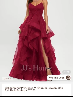 Vinröd balklänning med volanger - Säljer en vinröd balklänning från JJ's House med v-ringning, tunna axelband och dramatiska volanger i flera lager. Klänningen har en hög slits och är tillverkad i luftig tyll som ger en riktigt elegant känsla.
