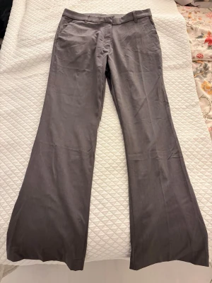 Mörk gråa kostymbyxor.  - Ett par högmidjade mörk gråa kostymbyxor med bootcut passform. 