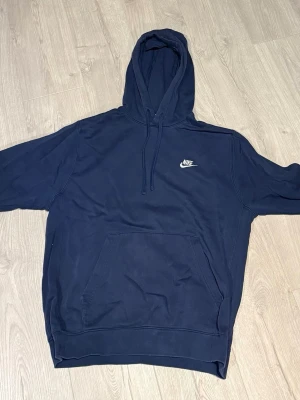 Nike hoodie i färgen mörkblå ungefär. - Nike hoodie i storlek M, i färgen blå. Den är i bra skick trots att jag använt den mycket!