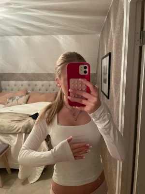 Vit långärmad topp från Gina Tricot - Säljer en vit långärmad topp från Gina Tricot med fyrkantig ringning. Topp i mjukt bomullsmaterial, figurnära passform och långa ärmar. Perfekt att styla med jeans eller kjol för en clean look.