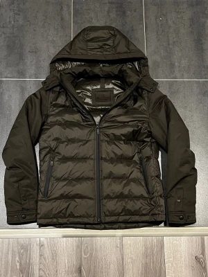 Massimo Dutti Dunjacka Herr - Tjena säljer denna tvärfeta Massimo Dutti dunjackan perfekt nu inför vintern, men också våren och hösten. Jackan passar S, fast än att det står M på jackan. Jackan är vattentät, vindtät, och fyllt med riktigt dun. Tidigare har den haft ett jätte litet hål/skrapmärke på ryggen men som vart fixat hos skräddaren och inte syns längre. Skriv gärna vid intresse!