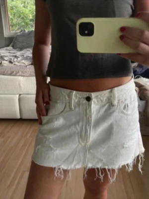 Vit lågmidjad jeanskjol med fransig kant - Säljer en jättefin lågmidjad vit jeanskjol från Abercrombie & Fitch! Det är w28 men den är insydd på sidorna så midjemåttet är 38 cm. Pris kan diskuteras 
