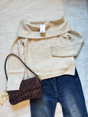 Ljusbeige Off-shoulder Kabelstickad Tröja från H&M - Produktbeskrivning •Snygg och kabelstickad off-shoulder tröja. •I ljus beige / cream färg.  •Köpt från H&M. •Såldes för 349kr. •I storlek S. •Passform som framhäver axlarna och ger en feminin, stilren look. •Perfekt både till vardag och fest. •Bröstmått: ca  •Längd: ca  •Trendig “clean girl / classy” stil  Mer information  •Skickas inom 24h! •Vid fler frågor eller om du vill ha fler bilder, skriv till mig så svarar jag genast! 