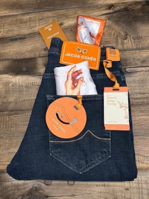 Jacob Cohën mörkblå jeans, slim fit - Snygga mörkblå jeans från Jacob Cohën med slim fit-passform. Jeansen har orange detaljer, exklusiv etikett och broderade sömmar. Tillverkade i högkvalitativt jeansmaterial med naturlig indigo-färgning. Kommer med en unik scarf i fickan och limited edition-taggar.