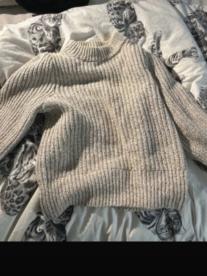 Beige trekvartärmad tröja från H&M - Säljer en beige stickad tröja från H&M. Tröjan har trekvartsärmad passform och är perfekt för kyligare dagar. Enkel att styla med jeans eller kjol för en avslappnad look.