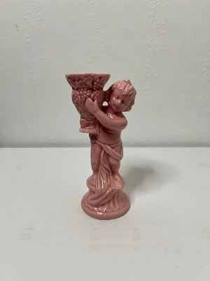 Supersöt retro keramikfigur ljusstake  - Bilderna visar en rosa keramikfigur som håller i en vas. Ljusstake 