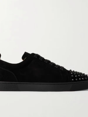 Svarta sneakers med nitar från Louboutin - Säljer ett par svarta sneakers från Louboutin i mocka med coola svarta nitar på tån och klassisk röd sula. Skorna har snörning och en platt sula, perfekt för dig som vill sticka ut med en edgy vibe.