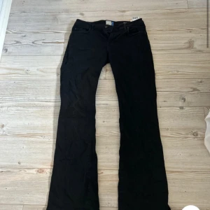 Svarta bootcut jeans från l.t.b - Svarta jeans från l.t.b i bootcut-modell. Snygg passform med utsvängda ben och normal midja. Tillverkade i mjukt jeanstyg som sitter skönt hela dagen. Perfekta för dig som gillar en tidlös och avslappnad stil.