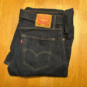 Levi's 559 mörkblå jeans W32 L34 - Mörkblå Levi's 559 jeans med klassisk femficksdesign och kontrastsömmar. Jeansen har rak passform och är tillverkade i slitstarkt denimtyg av bomull. Perfekta för dig som gillar en tidlös och clean look. Ikonisk läderpatch bak i midjan.