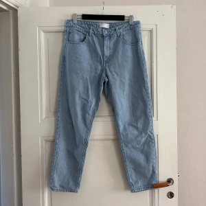 Ljusblå jeans från ASOS Design - Säljer ett par ljusblå klassiska jeans från ASOS Design. Modellen heter Classic Rigid och har raka ben, fem fickor och normal passform. Jeansen är tillverkade i 100% bomull och har en stilren, enkel look utan slitningar eller dekorationer.