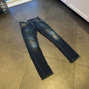 Replay Hyperflex jeans  - Säljer ett par mörkblå Replay Hyperflex jeans med snygga slitningar.                                         Obs!!! Hål i sömmen vid mellangärdet, men går enkelt att fixa hos skräddare. Se bild 4