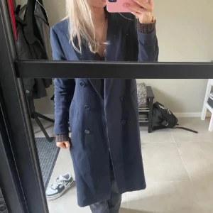 Mörkblå höstkappa  - Mörkblå kappa från hm! använd fåtal gånger och är i superbra skick! Inga skavanker Legat ihopvikt därav lite skrynklig! 